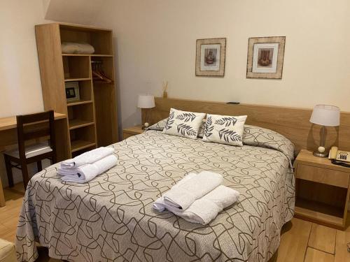 una camera da letto con un letto e asciugamani di Centro Plaza Hotel a Concordia