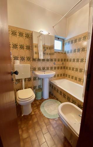a bathroom with a toilet and a sink and a tub at Casa Panorama in Salema