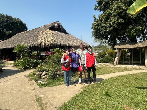 a group of people standing in front of a hut at Luong Son Homestay Ecolodge in Cao Bằng