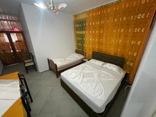a room with two beds and a table at Hotel Bar Restaurant Mete in Peshkëpi