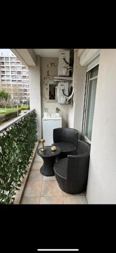 un patio avec deux chaises et une table sur un balcon dans l'établissement En face du vélodrome, à Marseille