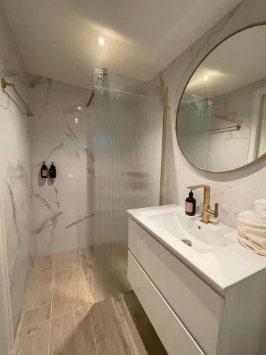 a bathroom with a shower and a sink and a mirror at Villa de Duinfazant in Bergen aan Zee