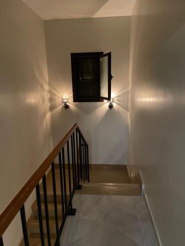 a staircase with two lights and a window on the wall at Marassi blanca in El Alamein