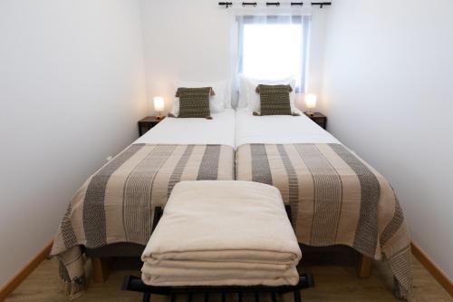 a bedroom with a large bed with two pillows at Casinha da Praia - Beachside Retreat Almoxarife in Praia do Almoxarife