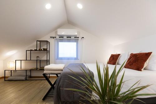 a bedroom with a bed and a chair and a window at Casinha da Praia - Beachside Retreat Almoxarife in Praia do Almoxarife