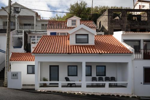 a white house with a red roof at Casinha da Praia - Beachside Retreat Almoxarife in Praia do Almoxarife