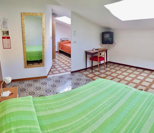 una camera con letto e televisore e una camera da letto di Albergo Natucci a Montecatini Terme