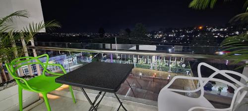 a table and chairs on a balcony at night at Jerusalem Hotel in Gitega