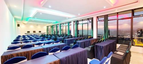 a room with blue chairs and tables and windows at Jerusalem Hotel in Gitega