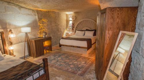 a bedroom with a bed and a mirror in a room at Theodora Village House in Urgup