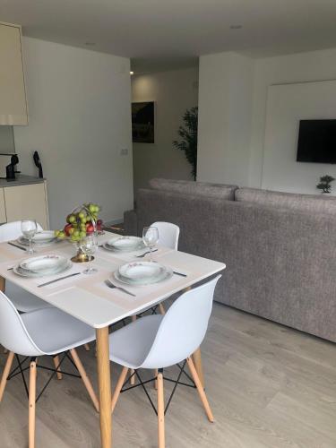 a white table with chairs and a couch at Apartamento Estrela do Mar in Nazaré