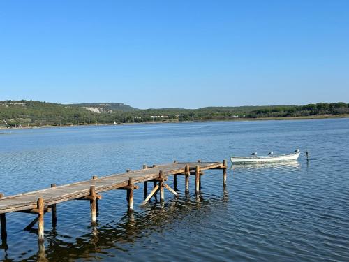 una barca sull'acqua accanto a un molo di Appartement spacieux de plein pied avec 2 chambres, cuisine, salon, terrasse à 2 minutes de la plage a Gruissan