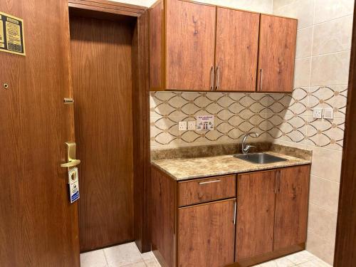 a kitchen with a sink and a wooden door at فندق بلانتي 2 in Al Madinah