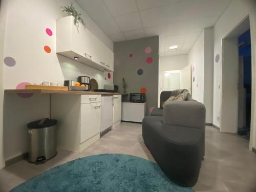 a living room with a chair and a kitchen at Neu Studio Leipzig Zentrum in Leipzig