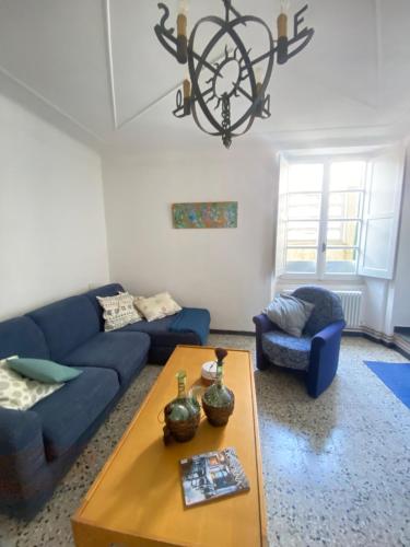 ein Wohnzimmer mit einem blauen Sofa und einem Tisch in der Unterkunft ‘’Perla Marina’‘ in Levanto