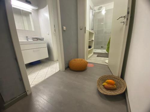 a bathroom with a sink and a bowl of fruit on the floor at Neu Studio Leipzig Zentrum in Leipzig