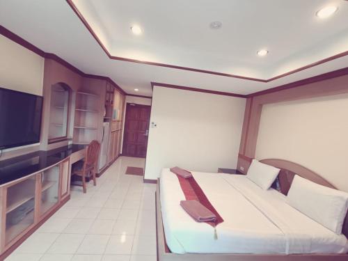 パタヤ・サウスにあるPauna Inn Pattayaのベッドとテレビ付きのホテルルーム