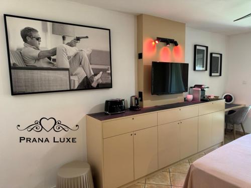 una habitación de hotel con TV y una habitación en Little Prana, en Saint-Gilles-les-Bains