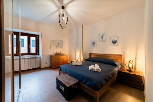 - une chambre dotée d'un lit avec deux chaussures blanches dans l'établissement Casa Anita, à Terracine