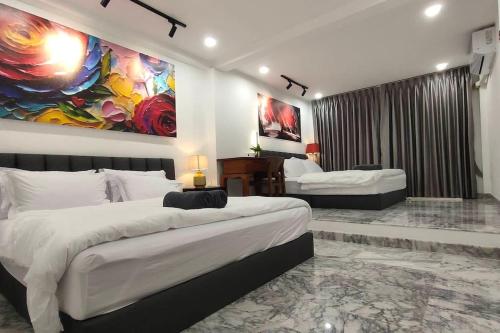 a bedroom with two beds and a painting on the wall at Private cozy house @Chatcuchak in Bang O