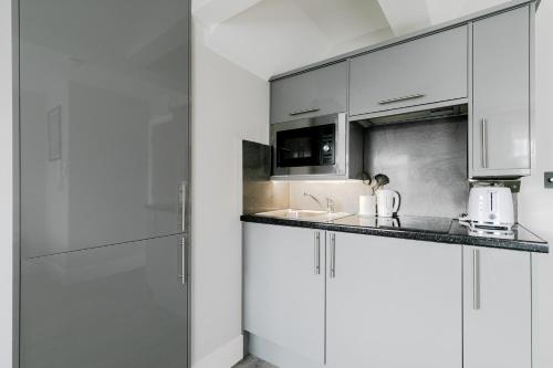 a kitchen with white cabinets and a counter top at London Central Studios in London