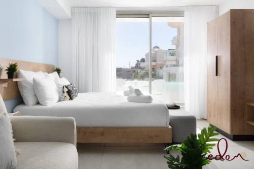 a bedroom with a large bed and a window at סוויטה מעוצבת עם מרפסת ליד הים - By Edomlux in Eilat