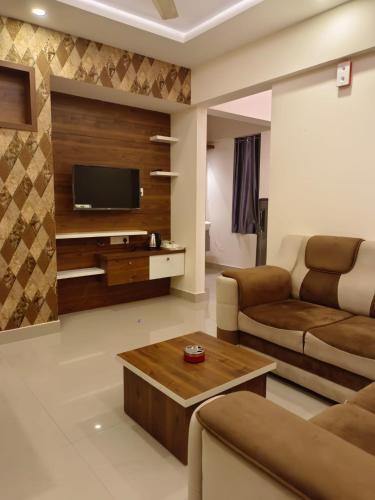 a living room with a couch and a tv at Vvp Airport Lounge in Nedumbassery