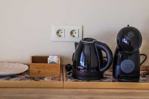 a black tea kettle on a counter next to a light switch at Eco complex Zdravets in Zdravets
