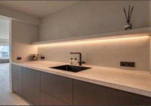 a kitchen with a sink and a counter top at Manon Knokke - appartement met zeezicht aan het Rubensplein in Knokke-Heist