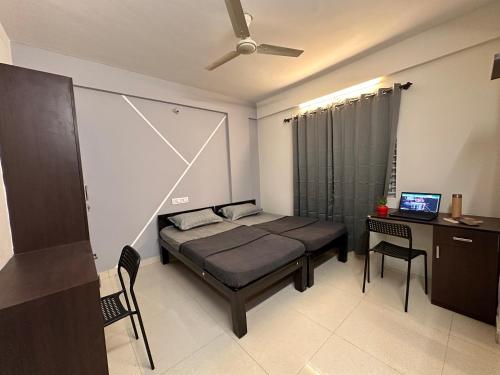 1 dormitorio con 1 cama y escritorio con ordenador en Bangalore Stays, en Bangalore
