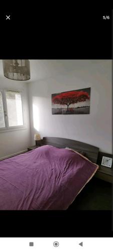 ニースにあるAppartement à Niceのベッドルーム1室(紫色のベッド1台付)が備わります。壁に絵画が飾られています。