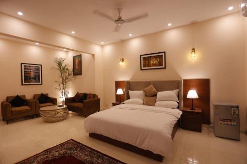a bedroom with a bed and a living room at Signature Boutique Hotel Karachi in Karachi