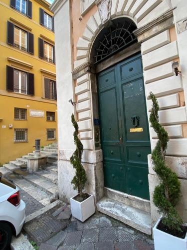 a green door on the side of a building at Trevi Steps in Rome