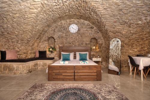 een slaapkamer met een bed in een stenen muur bij קשתות - מתחם אבן בצפת העתיקה - Kshatot - Stone Complex in Old Tzfat in Safed