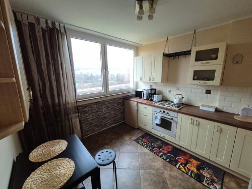 a small kitchen with white cabinets and a window at Stacja Kudowa in Kudowa-Zdrój