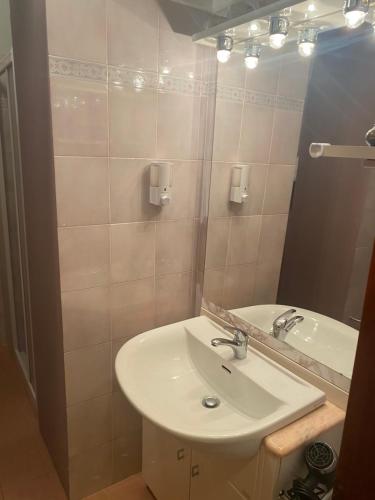 een badkamer met een wastafel en een spiegel bij Chiara House in Barga