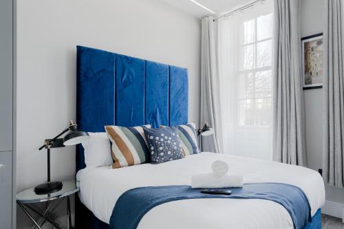 a bedroom with a large bed with a blue headboard at London Central Studios in London