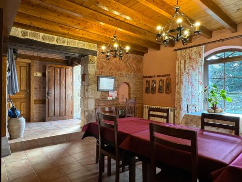 a dining room with a red table and chairs at Casa Rural La Socarrena in Luzmela