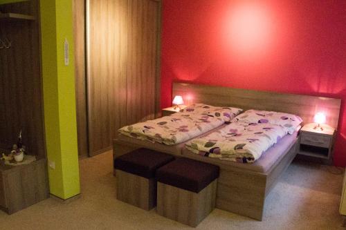 una camera da letto con un letto grande con una parete rossa di Motel Pávov a Jihlava