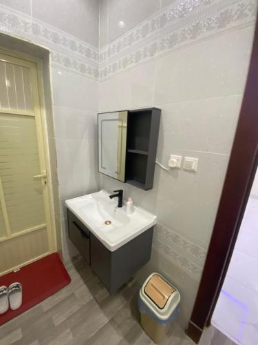 a bathroom with a sink and a tv on the wall at شقق الريان للعزاب والعوائل in Hafr Al Baten