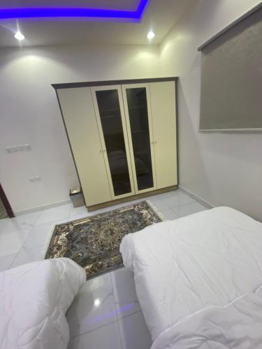 a bedroom with a bed and a carpet in front of a window at شقق الريان للعزاب والعوائل in Hafr Al Baten