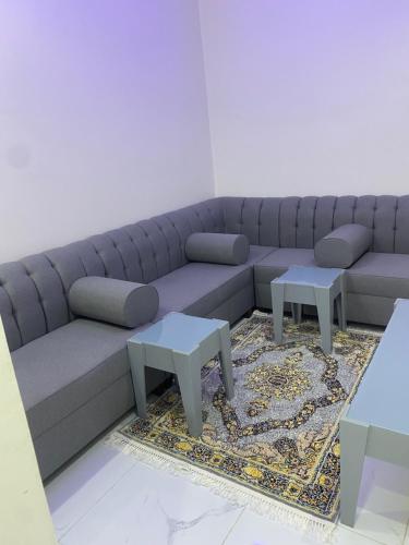 a living room with a couch and two tables at شقق الريان للعزاب والعوائل in Hafr Al Baten