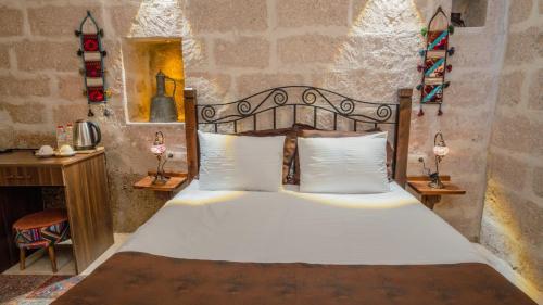 a bedroom with a bed in a stone wall at Theodora Village House in Urgup