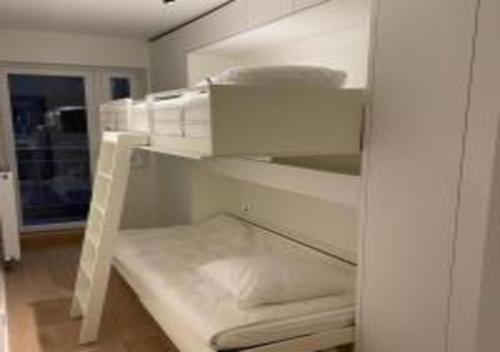 a white bunk bed in a room at Manon Knokke - appartement met zeezicht aan het Rubensplein in Knokke-Heist