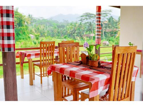 a dining room with a table and chairs and a window at Gongwi Cottages Sidemen in Sidemen