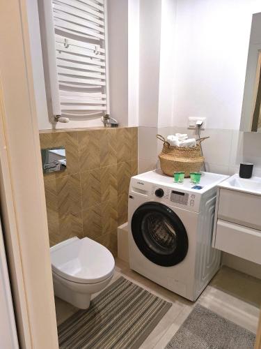 a bathroom with a washing machine and a toilet at Apartament Złoty Trójkąt z garażem podziemnym INTERNET światłowodowy 1000 Mbs Telewizja kablowa 205 programów in Serock