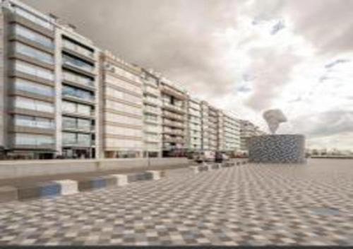 a view of a large building with a cloudy at Manon Knokke - 3-kamer appartement met zeezicht aan het Rubensplein in Knokke-Heist