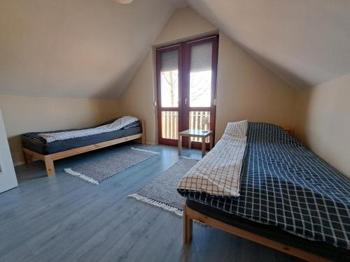 a attic room with two beds and a window at Berek Vendégház Fonyód in Fonyód