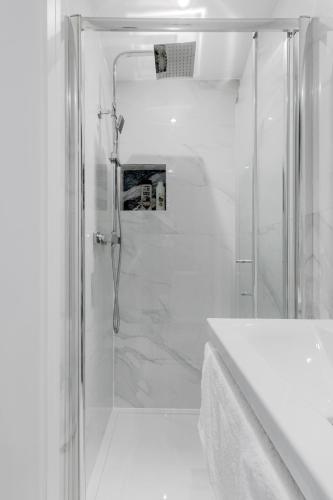 a white bathroom with a shower and a sink at London Central Studios in London