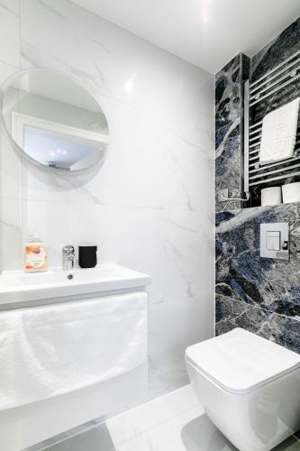 a white bathroom with a sink and a toilet at London Central Studios in London
